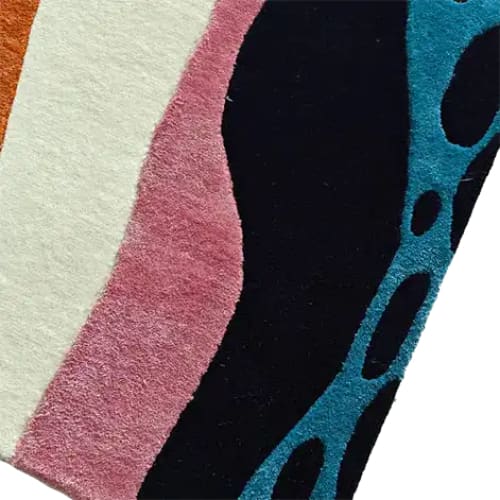 Close-up view of the Pattern Play Hand Tufted Wool Rug Runner showcasing vibrant abstract designs with blue, pink, and black colors. Ideal as a contemporary area rug, this versatile piece adds a stylish touch to kitchens, hallways, offices, or bathrooms. Made from wool, it's perfect for those seeking high-quality large area rugs for living rooms or as kitchen runner rugs.