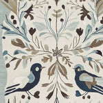 Close-up view of the Peaceful Winter Chorus hand tufted area rug, featuring a charming design with birds and botanical elements. This wool rug, perfect for living rooms, showcases intricate detailing with soft hues of blue, brown, and cream, adding a touch of elegance to any space.