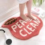 A cozy and stylish Peachy Clean Bathmat in a vibrant peach color, featuring the words 'PEACHY CLEAN' in bold white letters. This runner rug is perfect for adding a touch of charm to your bathroom decor. Ideal for use as a bathroom runner rug, this cotton rug offers comfort and style, making it a great addition to kitchen rugs or hallway runner rugs as well.