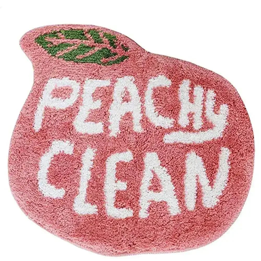 A charming peach-shaped runner rug featuring the words 'Peachy Clean' in bold white letters against a soft pink background. Ideal for adding a playful touch to kitchens, hallways, or bathrooms, this cotton rug combines style with practicality.