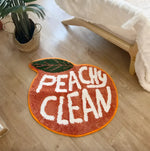 A vibrant Peachy Clean bathmat shaped like a peach, adding a playful touch to any room. This runner rug is perfect for kitchens, hallways, or bathrooms, blending style with functionality. Made from soft cotton, it brings warmth and comfort to your space.