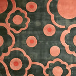 This vibrant area rug, ideal for a bedroom or dining room, features an abstract floral pattern with peach and coral accents on a dark background. The wool rug's bold design adds a touch of elegance and warmth, making it perfect for bedroom rugs or dining spaces.