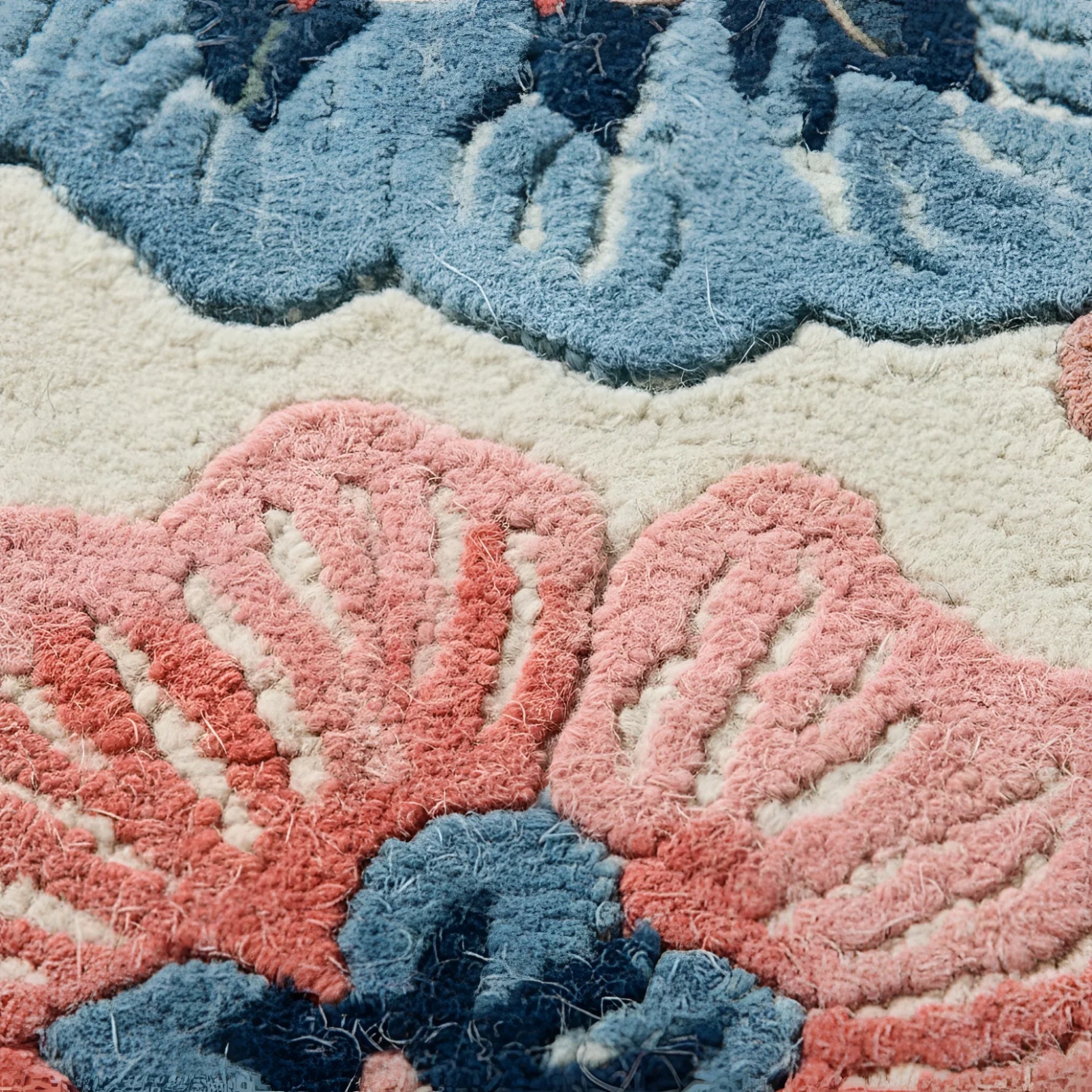 Close-up of a textured rug with floral patterns in blue and pink.