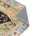 Persian Beauty Hand-Painted Floral Art Rug corner fold detail with red rose on cream field, blue outer border folded, grey backing