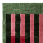 A close-up view of the Perspective Line Fall Hand Tufted Area Rug showcasing its contemporary design with bold green and pink stripes. Perfect for adding a modern touch to living room area rugs, this 8x10 wool rug brings a vibrant aesthetic to any space.