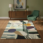 Living room with a colorful abstract rug, green chair, wooden sideboard, and abstract art on the wall.