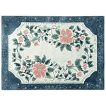 This stunning area rug features a vibrant floral design with large pink blooms and lush green leaves, set against a soft background. The intricate pattern is framed by a rich blue border, making it a perfect addition to any living room looking for a touch of elegance. Made from high-quality wool, this hand-tufted floral rug combines style and durability, ideal for those seeking beautiful rugs for living room spaces.