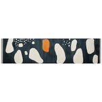 A stylish runner rug featuring an abstract design with white and orange shapes on a dark background, perfect for adding a contemporary touch to kitchens, hallways, or bathrooms. This hand-tufted wool rug combines modern aesthetics with functionality, making it an ideal choice for those seeking quality kitchen runner rugs or hallway runner rugs.