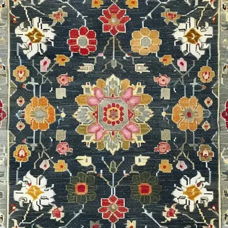This is a close-up view of the Petal Illusion Hand Knotted Area Rug, featuring a vibrant floral pattern with intricate designs in hues of red, pink, orange, and white against a dark background. Perfect for those seeking living room rugs 8x10, this vintage rug adds a touch of elegance reminiscent of Persian rugs, making it an ideal choice for any rugs for living room setting.