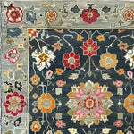Close-up of the Petal Illusion Hand Knotted Area Rug showcasing a vintage Persian-inspired floral design. The intricate pattern features vibrant red, orange, and pink flowers on a dark background, perfect for adding elegance to living room rugs 8x10.