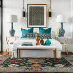 Modern bedroom with a bed, nightstands, lamps, blue decorative rug and pillows.