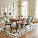 Dining room with a wooden table and colorful chairs on a patterned rug.