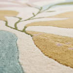 Close-up of a textured rug with floral patterns in pastel colors