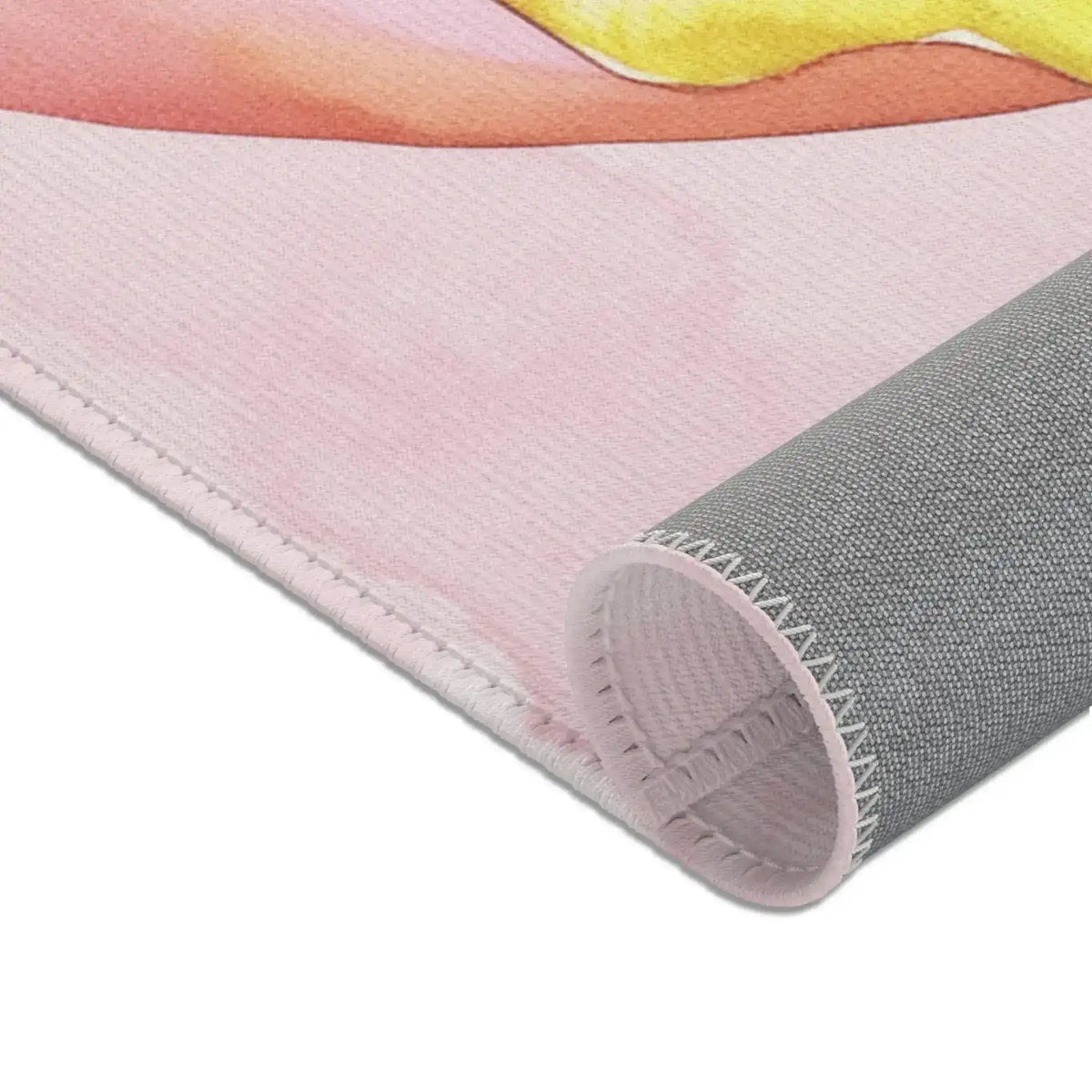 Pink Donut Drip Accent Rug lower corner pink watercolor base with yellow drip and rolled gray backing side view