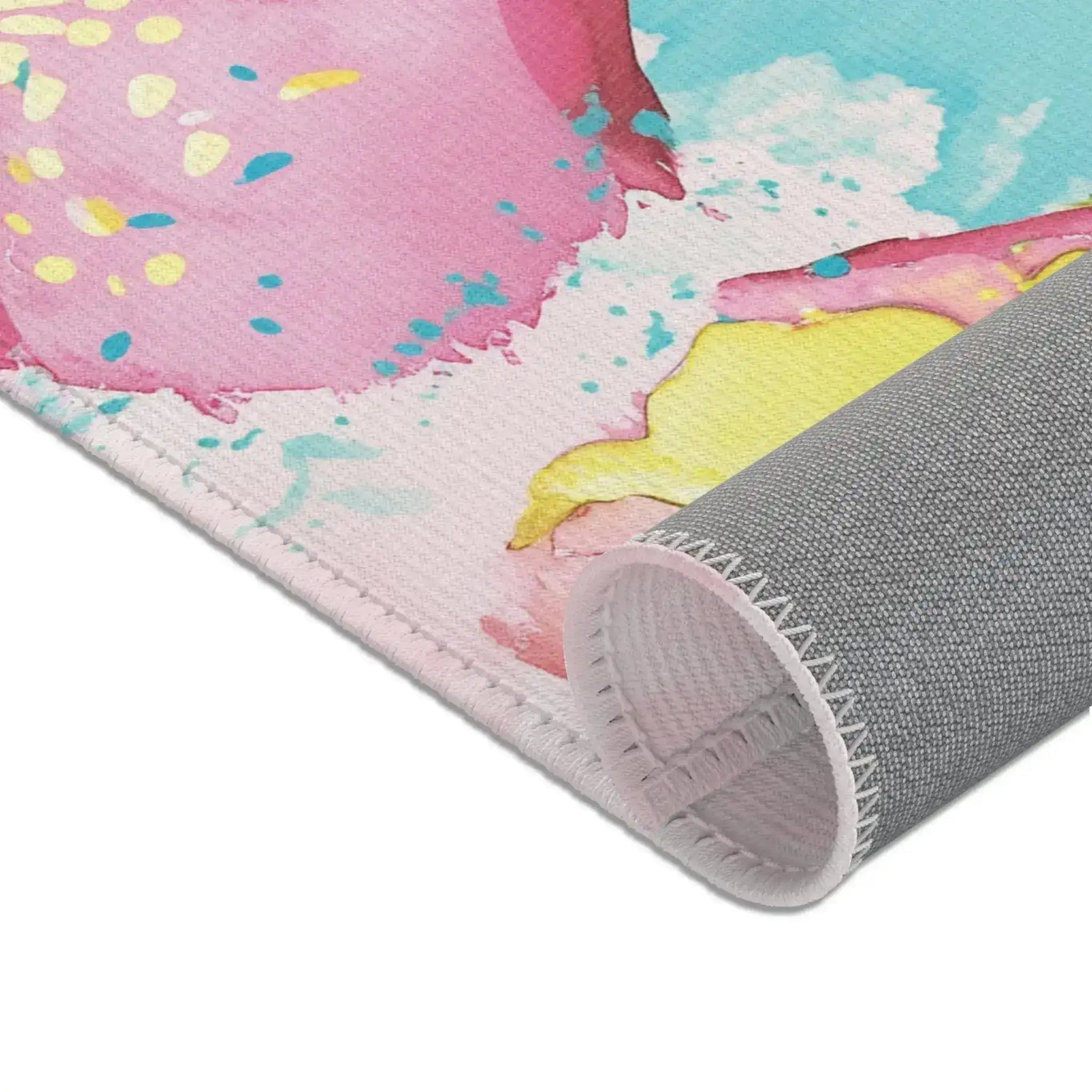 Pink Donut Drip Accent Rug close-up corner with pink glaze and teal sprinkles print and rolled gray backing