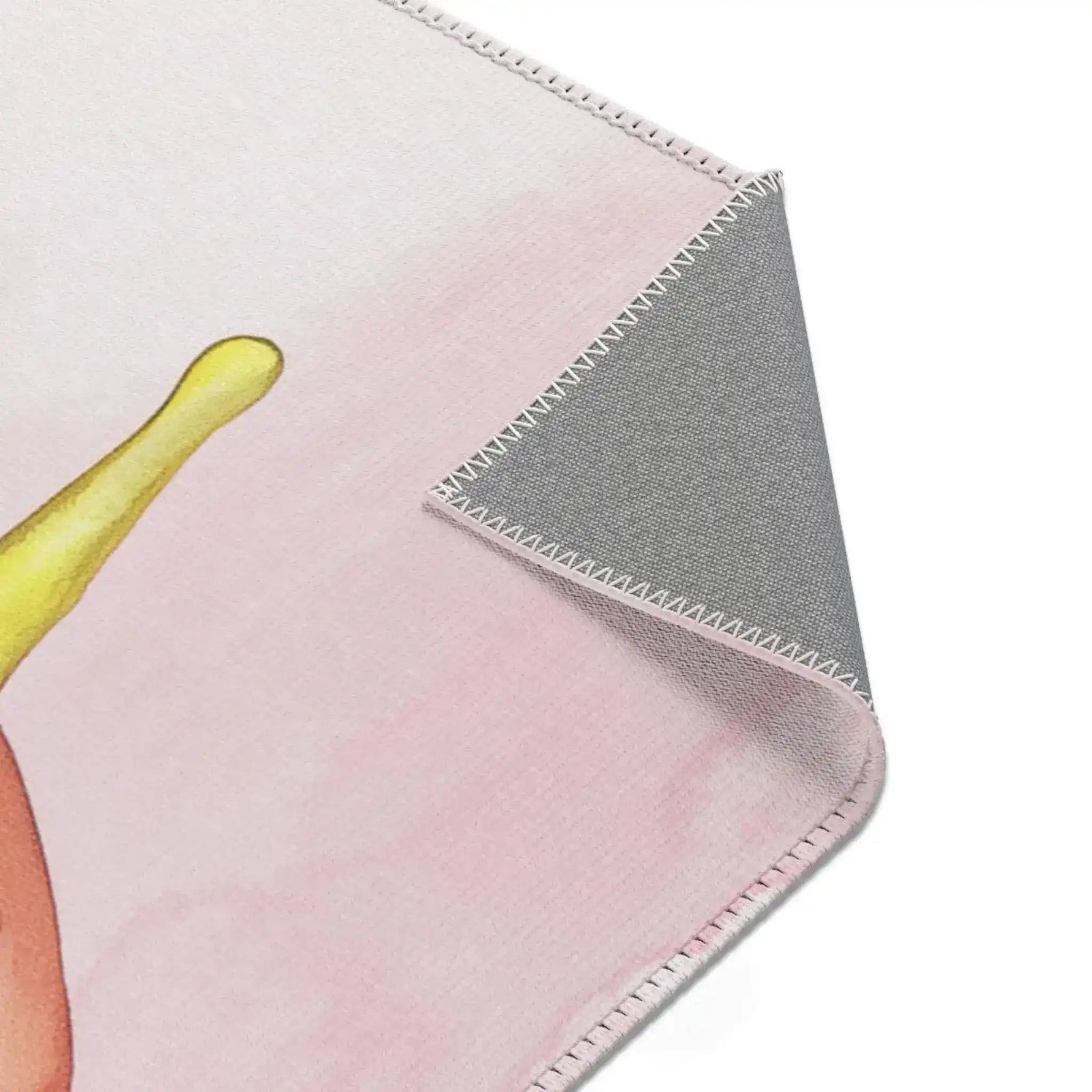 Pink Donut Drip Accent Rug pale pink upper corner with yellow glaze drip and gray anti-slip backing fold