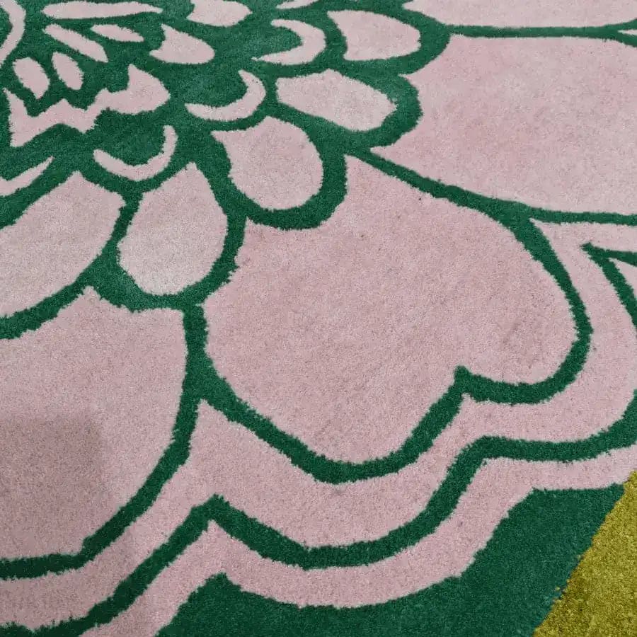 Close-up view of a pink Ginkgo leaf pattern on a hand-tufted wool area rug, perfect for large living rooms. The intricate green outlines add a touch of elegance, making it an ideal choice for living room rugs sized 8x10.