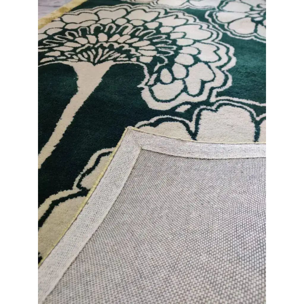 Close-up view of a wool area rug featuring intricate floral patterns with green and cream colors, ideal for large living rooms. This 8x10 living room rug showcases the quality craftsmanship of hand-tufted wool, perfect for adding a touch of elegance to your space.