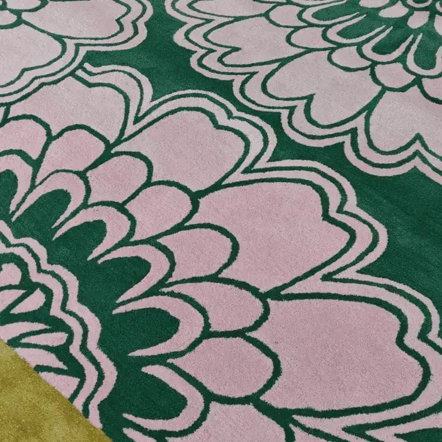 Close-up view of a hand-tufted wool area rug featuring a pink gingko leaf pattern on a green background. Ideal for large living rooms, this stylish 8x10 wool rug adds a touch of elegance to any living space.