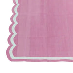 A charming pink handwoven reversible cotton scalloped area rug, perfect for adding a touch of boho style to large living rooms. This versatile rug, measuring 3' x 5', showcases intricate scalloped edges and a soft cotton texture, making it an ideal choice for those seeking stylish large area rugs or rugs for living rooms.