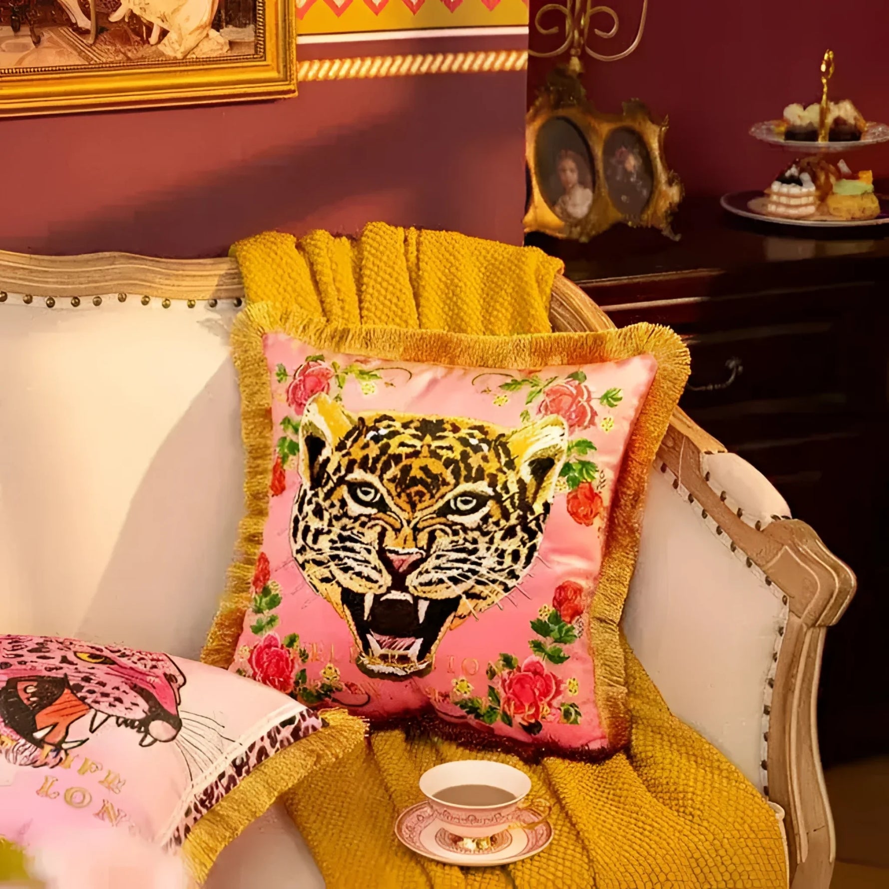 Pink leopard face throw pillow with gold fringe and floral accents, perfect for adding a bold decorative touch to any living space.