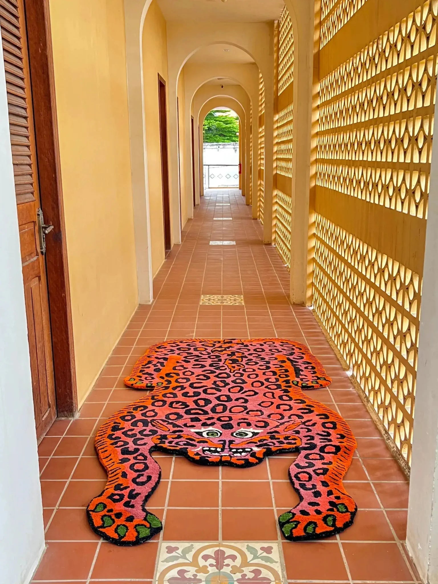 A vibrant Pink Leopard Yogi Accent Wool Rug in a hallway, showcasing its unique leopard design. This large area rug is perfect for adding a bold touch to living rooms, with its striking colors and vintage appeal. Ideal for those seeking living room rugs 8x10 and wool rugs with personality and style.