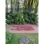 Vibrant pink leopard yogi accent wool rug displayed outdoors on a wooden deck, surrounded by lush green plants, showcasing its unique and artistic design. Ideal for adding a pop of color to living room spaces. Perfect as a living room rug 8x10, this vintage wool rug adds a bold touch to any area.