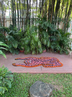 Vibrant pink leopard yogi accent wool rug displayed outdoors on a wooden deck, surrounded by lush green plants, showcasing its unique and artistic design. Ideal for adding a pop of color to living room spaces. Perfect as a living room rug 8x10, this vintage wool rug adds a bold touch to any area.