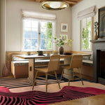 A stylish dining room featuring a Pink Petal Hand Tufted Wool Rug. This contemporary area rug, perfect for living room rugs 8x10, showcases a vibrant abstract design that complements the cozy dining room setting. The wool rug adds warmth and texture, making it an ideal choice for dining room carpets and enhancing the overall aesthetic of the living room.