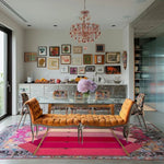 A vibrant living room featuring a Pink Prism Geometric Hand-Tufted Wool Rug, adding a contemporary touch to the decor. The area rug displays bold geometric patterns with shades of pink, perfectly complementing the eclectic mix of vintage and modern elements in the room. The wool rug enhances the living room's aesthetic, making it a cozy and stylish area for relaxation and social gatherings.