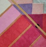 Close-up view of the Pink Prism Geometric Hand-Tufted Wool Rug showcasing its vibrant geometric pattern with shades of pink, purple, and red. Ideal for adding a contemporary touch to living room area rugs, this wool rug combines modern design with vintage charm, perfect for enhancing any living room decor.