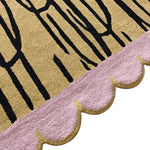 Close-up view of a contemporary art hand-tufted area rug, featuring a unique pink scalloped edge and abstract black lines on a beige background. Perfect wool rug for adding a stylish touch to living rooms, especially in the 8x10 size.