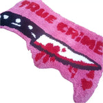 Vibrant pink area rug with a bold 'True Crime' design, featuring a graphic of a knife, perfect for adding a unique touch to living room area rugs. Ideal for those seeking distinctive rugs for living room decor.
