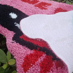 Close-up view of a colorful area rug featuring bold pink, red, and black hues, perfect for adding a touch of flair to living room area rugs. The intricate design and plush texture make it an ideal choice for rugs for living room decor.