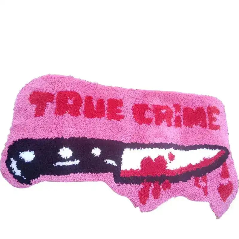 A quirky and bold pink area rug designed for true crime enthusiasts, featuring the words 'TRUE CRIME' and a graphic of a knife with red accents. Perfect for adding a unique touch to living room area rugs and ideal for those looking for distinctive rugs for living room spaces.