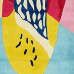 Close-up of a vibrant, abstract hand-tufted area rug featuring bold colors and playful patterns. This contemporary wool rug is perfect for adding a splash of color to any living room, making it an ideal choice for those seeking large living room rugs with a modern flair.