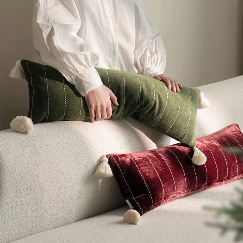 Stylish throw pillows in plush velvet with tassels, featuring a green and a red design, perfect for adding a touch of elegance to your living space.