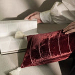 Plush velvet throw pillow with tassels, featuring elegant stitched lines, adding a touch of luxury to any decor.