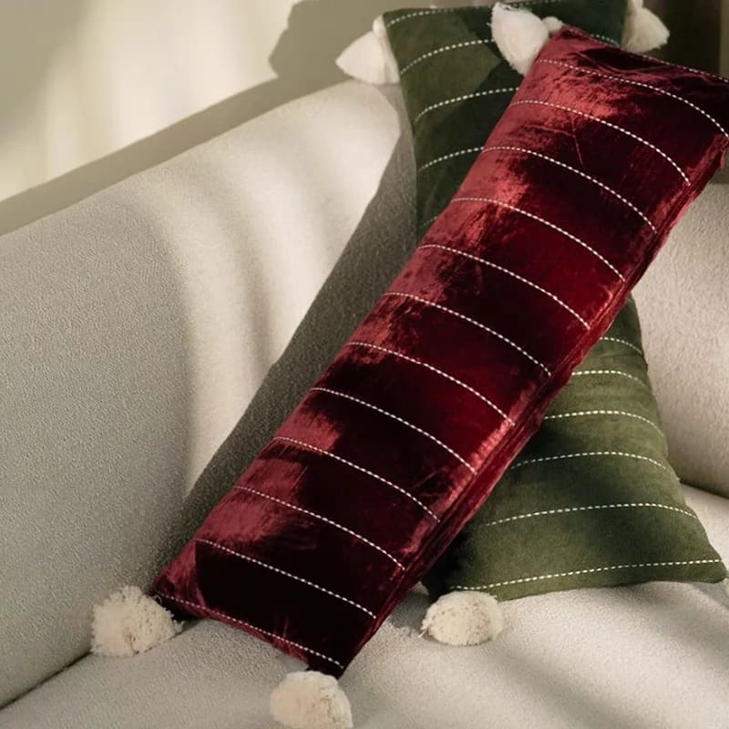 Plush velvet throw pillows with tassels in rich burgundy and deep green, adding a touch of elegance to any couch or decor.