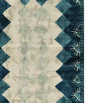 A contemporary wool area rug featuring an abstract geometric pattern with a blend of soft beige and deep teal tones. Perfect for adding a modern touch to living rooms or offices, this hand-tufted rug showcases intricate detailing and a unique design that complements various decor styles.