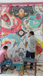 Artisans crafting a Prismatic Core Hand Tufted Rug in vibrant colors, ideal for large living room spaces. This wool rug features a vintage abstract design, perfect as a statement piece in any living room area.