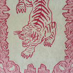 Close-up view of the Prowess in Pink Garden Hand-Tufted Rug showcasing an intricate red tiger design on a cream wool background. Perfect for adding a bold statement to a living room, this area rug blends artistic flair with luxury, ideal for large living room spaces.