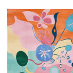 Vibrant and artistic hand tufted area rug featuring a psychedelic garden bloom design. This contemporary wool rug showcases a mix of bold colors like pink, orange, blue, and green, making it a standout piece for large living room spaces.