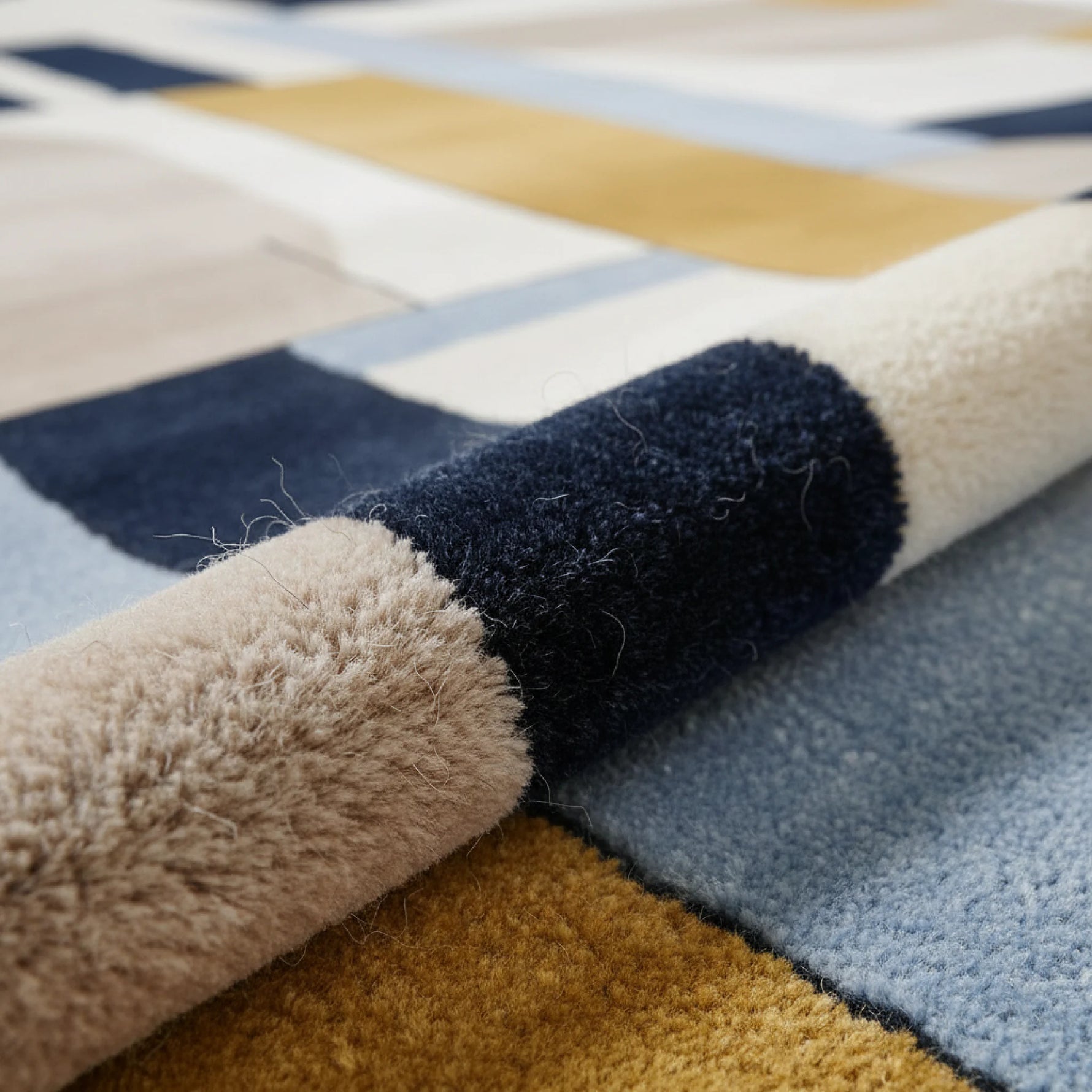 Close-up of a multicolored geometric-patterned rug with soft texture.
