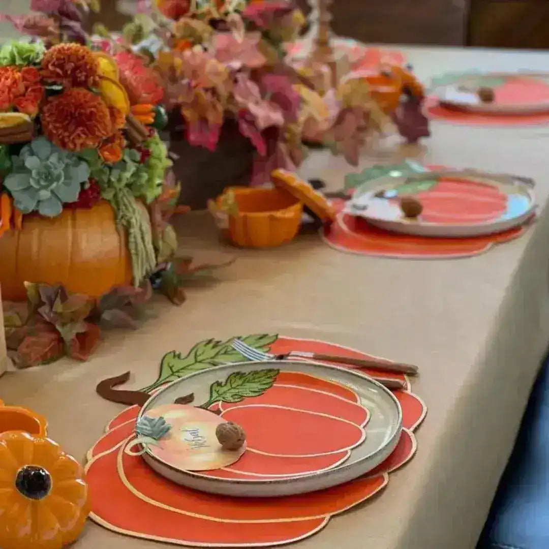 Harvest table with pumpkin-shaped placemat, pumpkin plate, walnut place-card, and marigold fall centerpiece