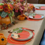 Harvest table with pumpkin-shaped placemat, pumpkin plate, walnut place-card, and marigold fall centerpiece