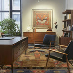 The Pyramid Dreamscape Hand Knotted Area Rug adds a touch of elegance to this modern living room. Featuring a vintage design, the large living room rug showcases intricate patterns reminiscent of Persian rugs. Its rich colors complement the wooden furniture, creating a warm and inviting atmosphere.