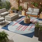 Outdoor patio with gray sofa, fire pit table, and geometric rug on a brick wall background.