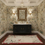 Bathroom with ornate wallpaper, black vanity, and decorative rug.