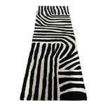 A stylish black and white runner rug featuring an abstract zebra stripe pattern, perfect for adding a contemporary touch to your kitchen, hallway, or bathroom. This hand-tufted wool rug blends modern design with timeless elegance, ideal as a kitchen runner rug or hallway runner rug.